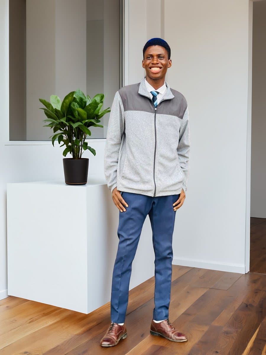 Emmanuel Adegbayi smiling, standing in a bright room